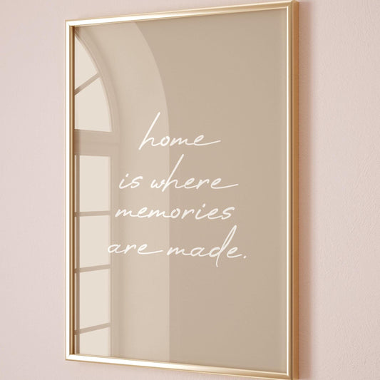 May include: A framed print with a gold-coloured frame. The print has a beige background with the white cursive text: "home is where memories are made."